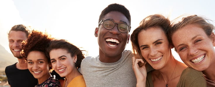 A diverse group of friends smiles for a photo.