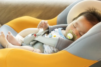 Baby child fastened with security belt in safety car seat