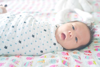 Cute adorable newborn baby boy swaddled