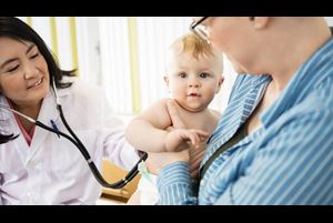 Baby Being Examined By Doctor While Carried By Mother