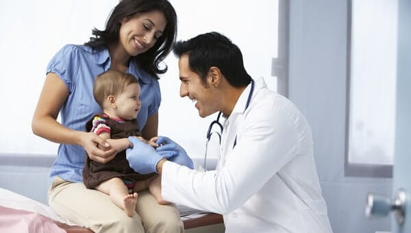 Doctor In Surgery Examining Baby Girl