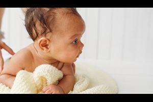African American baby lying on their stomach with their head up