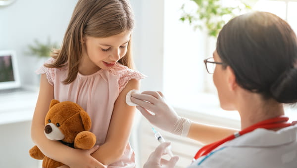 Female physician comforting a young child getting a vaccination