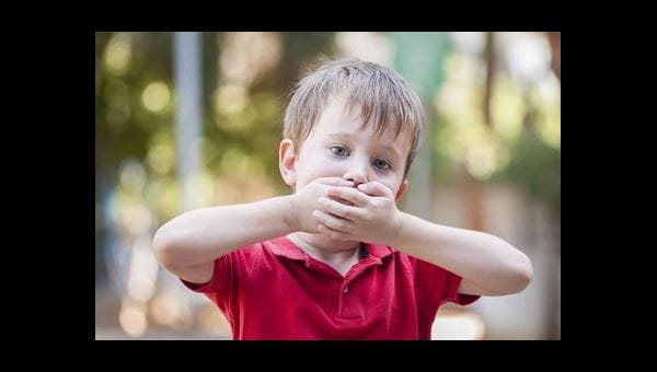 A child holding his mouth while he has the hiccups