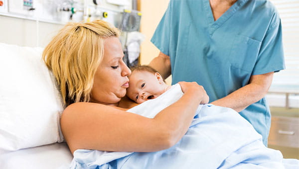 A mom holds her newborn baby shortly after giving birth.