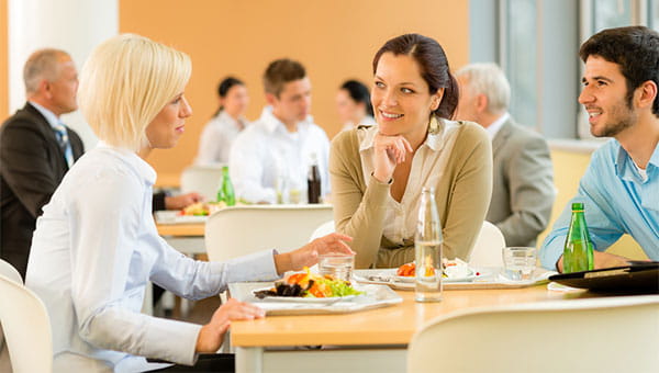 colleagues having lunch together three people sitting at a lunch table talking