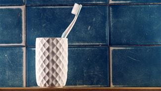A toothbrush is in a toothbrush holder in the bathroom