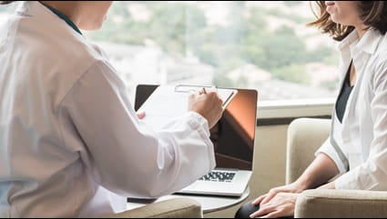 A young woman talks with her doctor.