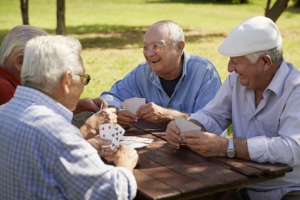 Group of elderly men playing cards and talking to each other