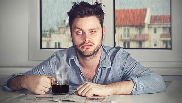 A man with coffee deprived of sleep