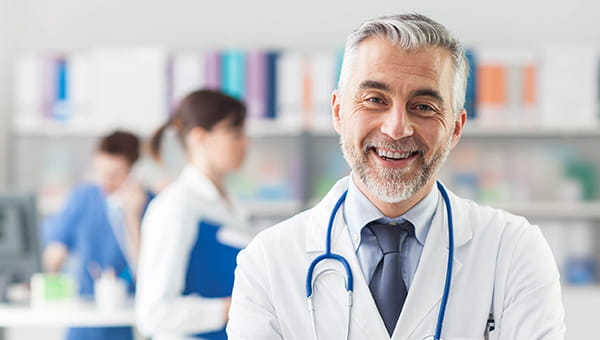 a male doctor in white lab coat smiling warmly