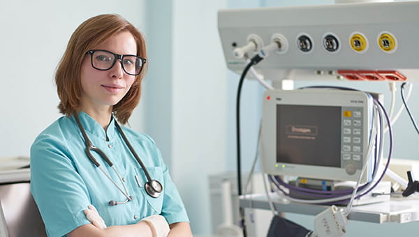female nurse in front of a hospital machine