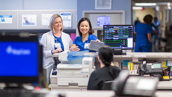 BayCare nurses are talking in a hospital unit.