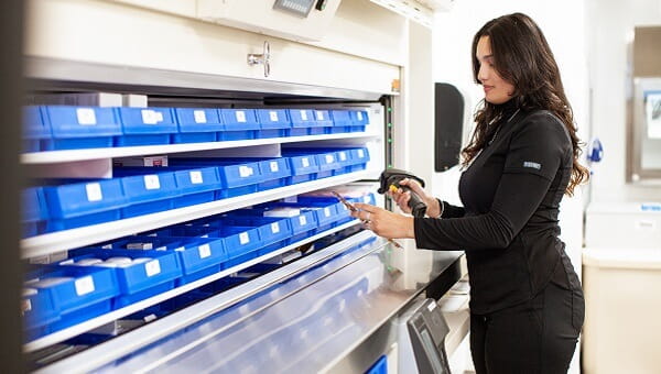 female baycare professional wearing black scrubs and scanning supplies