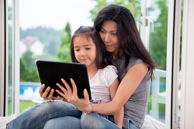 A woman and her daughter use a tablet for an online doctor visit.
