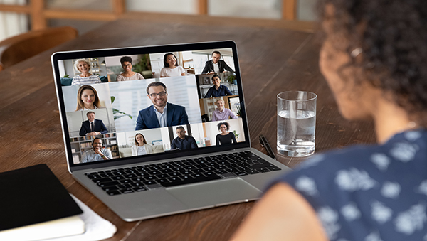 woman looking at laptop screen showing group video call