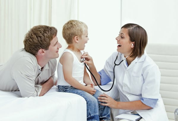 A father is watching his young son get a check up from his pediatrician.