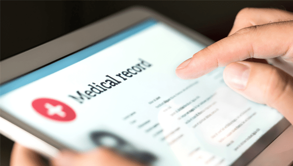 close up view on a finger on tablet screen reading medical records