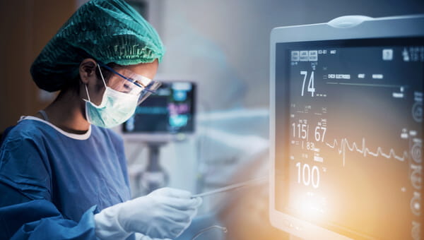 Medical provider in PPE looking at test results near a monitor