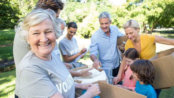 A smiling group of volunteers packing boxes