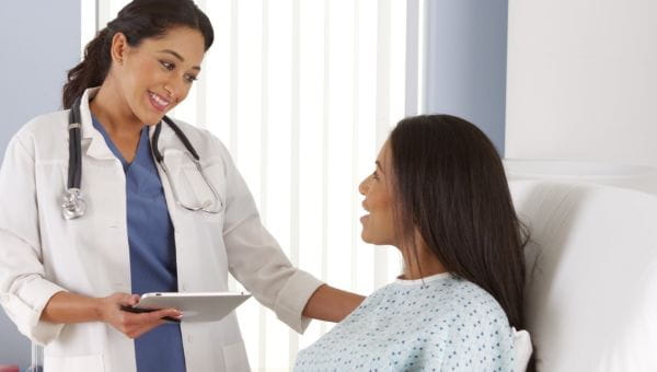 Female nurse comforting female patient