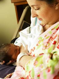A mother is breastfeeding her newborn baby.