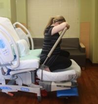 A woman demonstrating a maternity birthing position, option 7