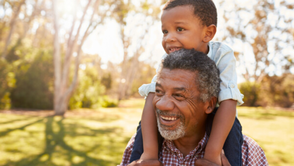 smiling father with his son on his shoulders