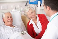 Doctor speaking to man in a hospital room and his wife