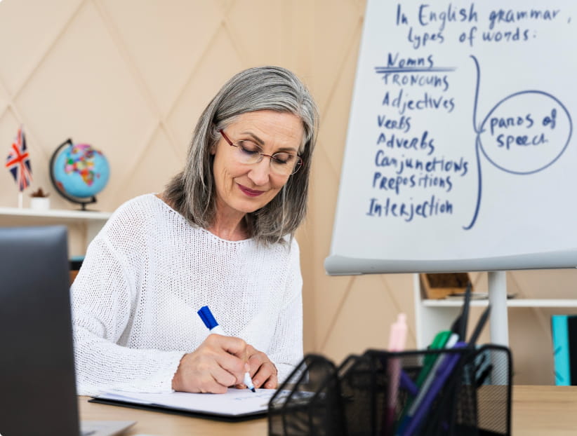 Lady writing on a tablet in front of a whiteboard.