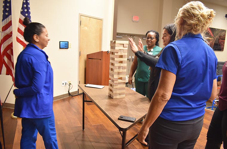 Team members stand around game.