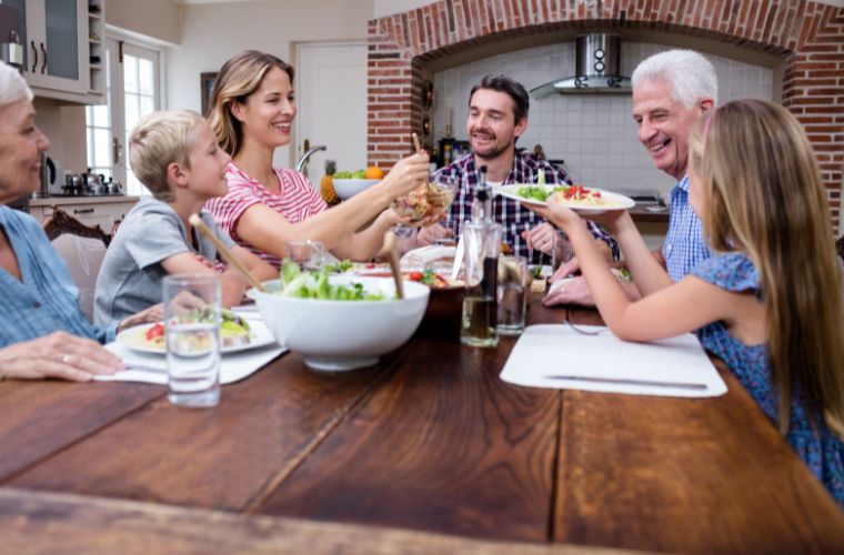 A family enjoying dinner together at a table, sharing a meal and conversation.