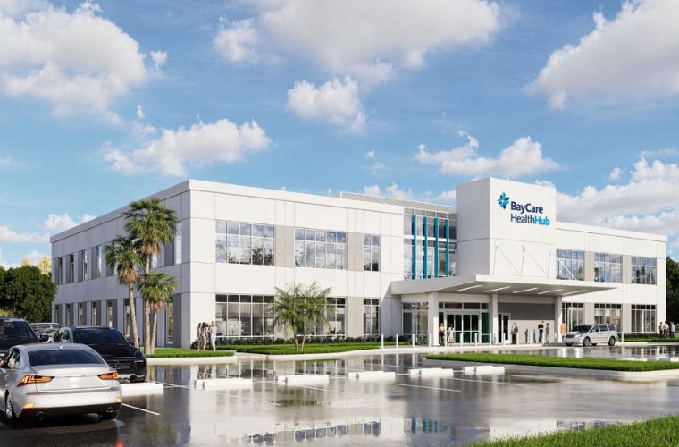 An artist's rendering of the exterior of BayCare HealthHub (Manatee). The picture shows the outside of a modern, multi-story office building with a spacious parking lot.