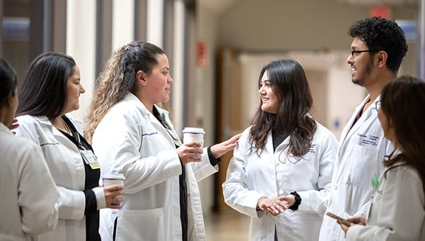 Six BayCare residents stand in a circle and talk.