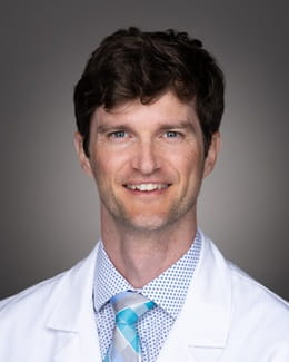 Dr. Brian Stephenson's headshot wearing a lab coat 