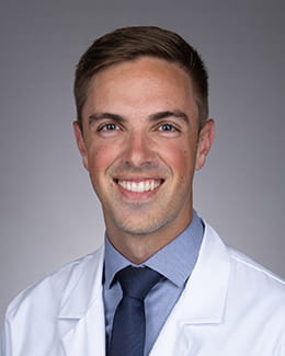 Travis Hotchkiss headshot in a lab coat