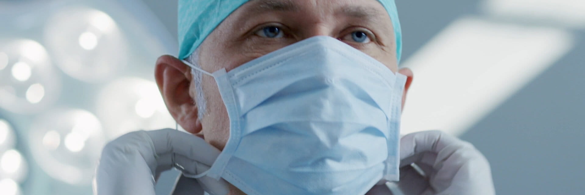 Surgeon putting on a face mask