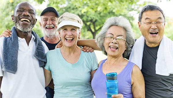 A group of senior men and women are smiling and laughing after exercising