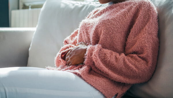 a woman sitting on her couch with her arms crossed