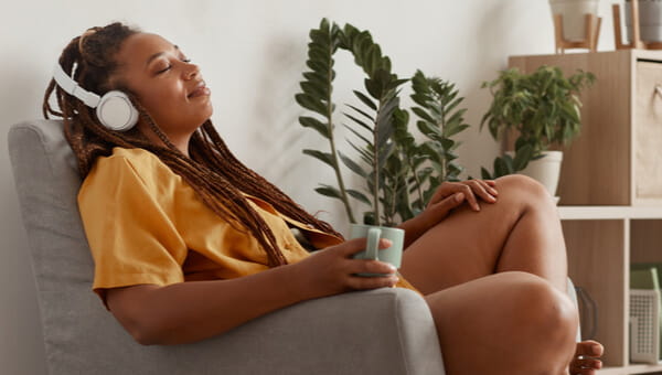 Lady sitting in a chair listening to something on her headphones