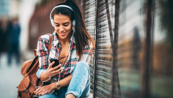 Lady looking at her phone on a park bench
