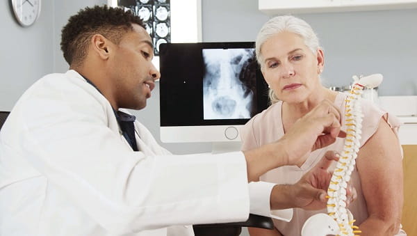 Male physician explaining spine surgery to a patient