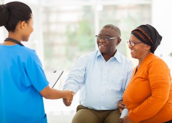 Male patient with wife shaking nurses hand