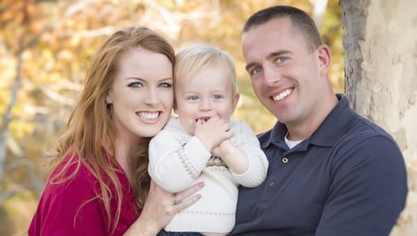 Smiling man, woman and baby.