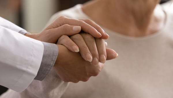 A doctor holding a patient's hand.