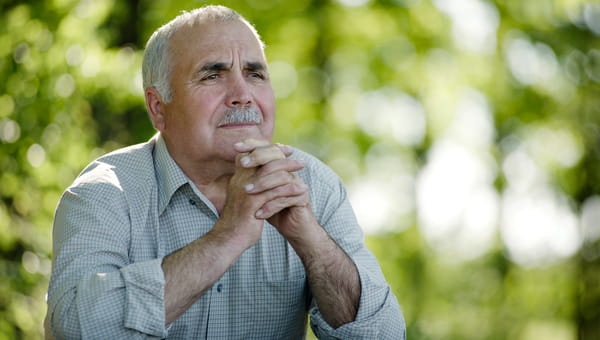 A senior man has a serious look on this face.