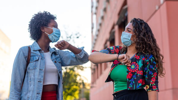 Young and friendly african girl and caucasian girl keeping social distance