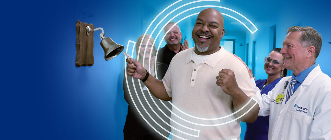 Cancer patient ringing the Victory bell with family, doctors and hospital staff.