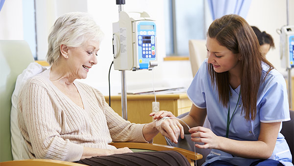 Lady sitting with a nurse who is working on her IV