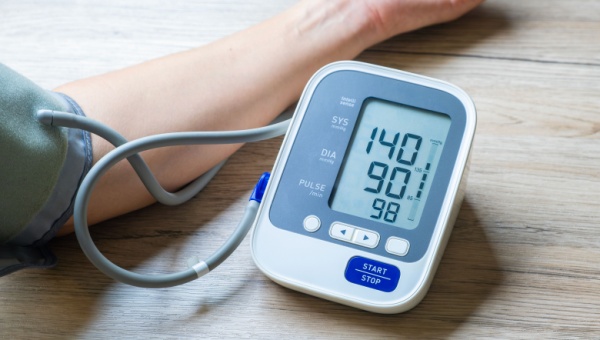 A person holds a blood pressure monitor, emphasizing the importance of monitoring high blood pressure for health management.